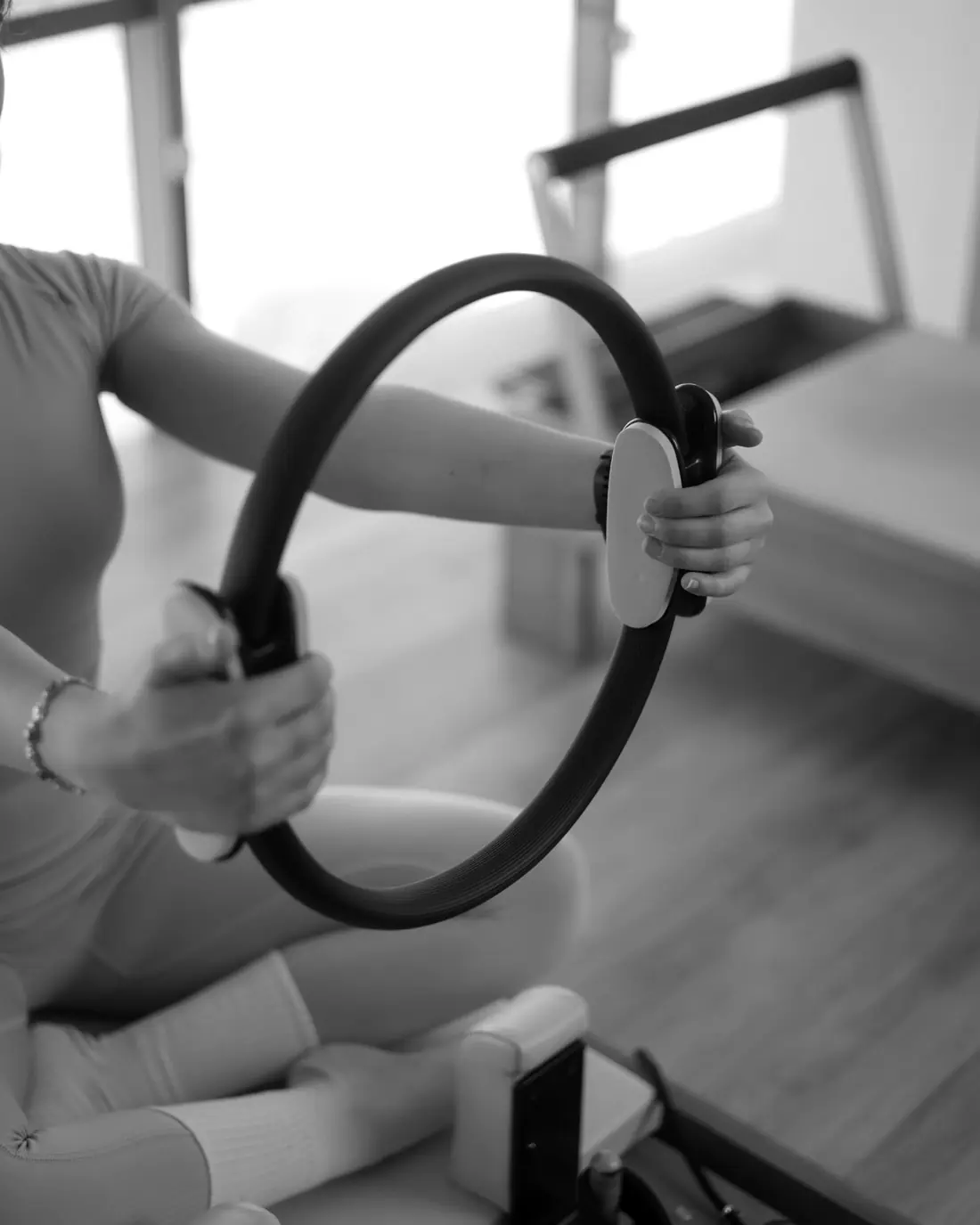 Close-up of hands pressing a Pilates magic circle during a class