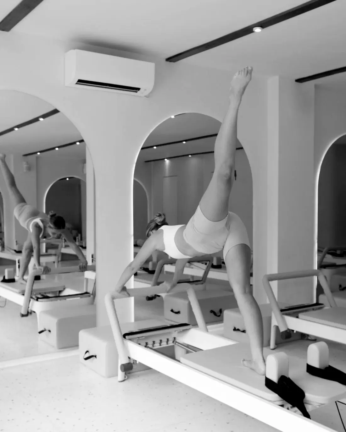 Woman holding a standing balance on a Megaformer-style carriage